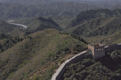the Great Wall of China, a watch tower, the northern mountains, a highway in the distance