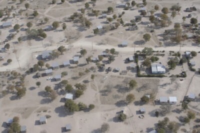desert town at the edge of the Okavango Delta, dirt roads, scattered trees, and small houses