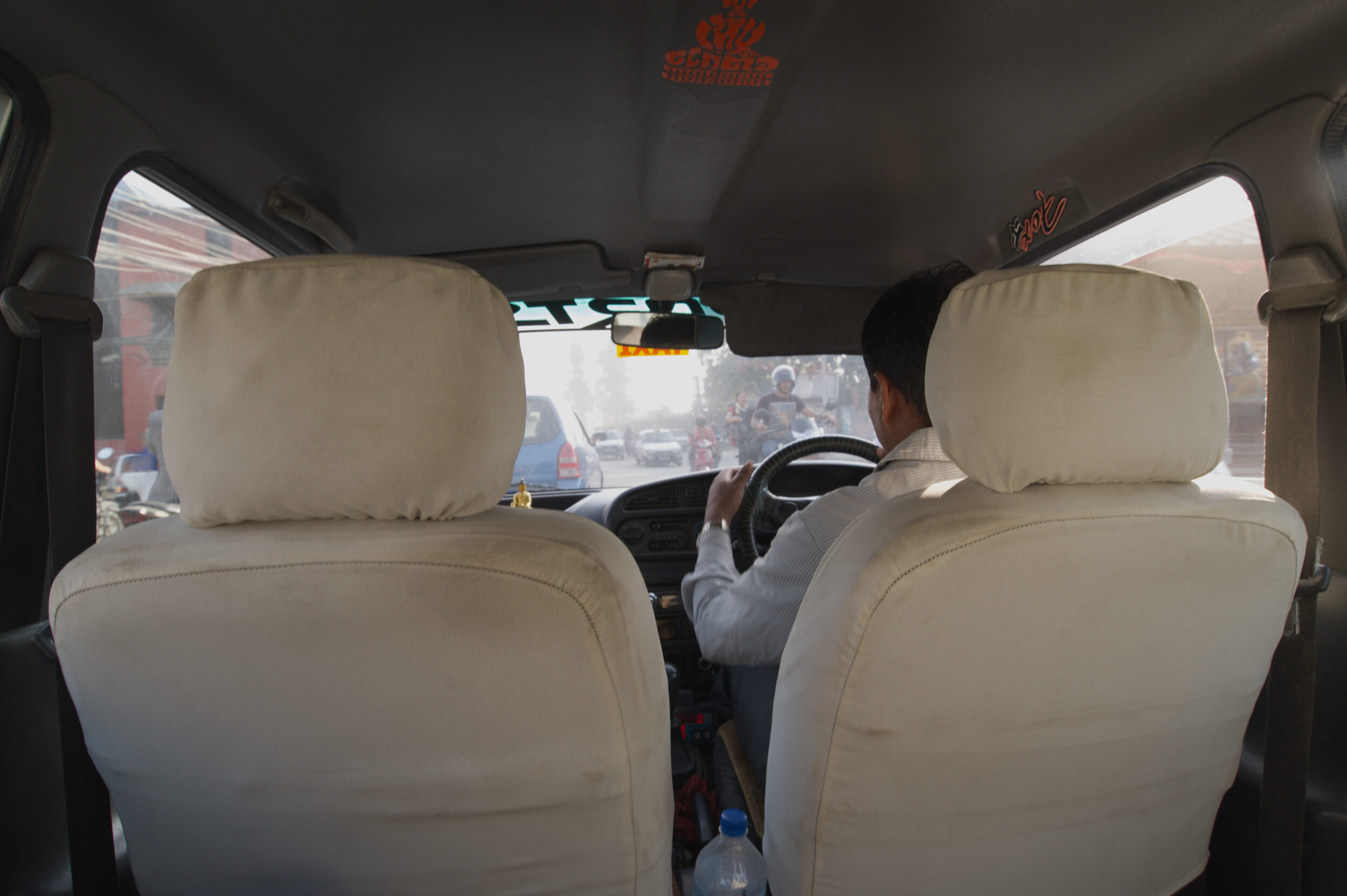 inside a taxi, driving through town in in Nepal